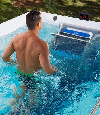 Dual-temperature swim spa hot tub zone with hydromassage seating