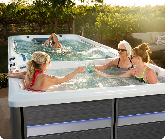 Dual-temperature swim spa shared cabinet and separated water zones
